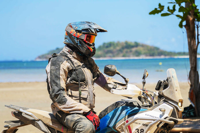 Motorrijder met adventure motorhelm in natuurlandschap